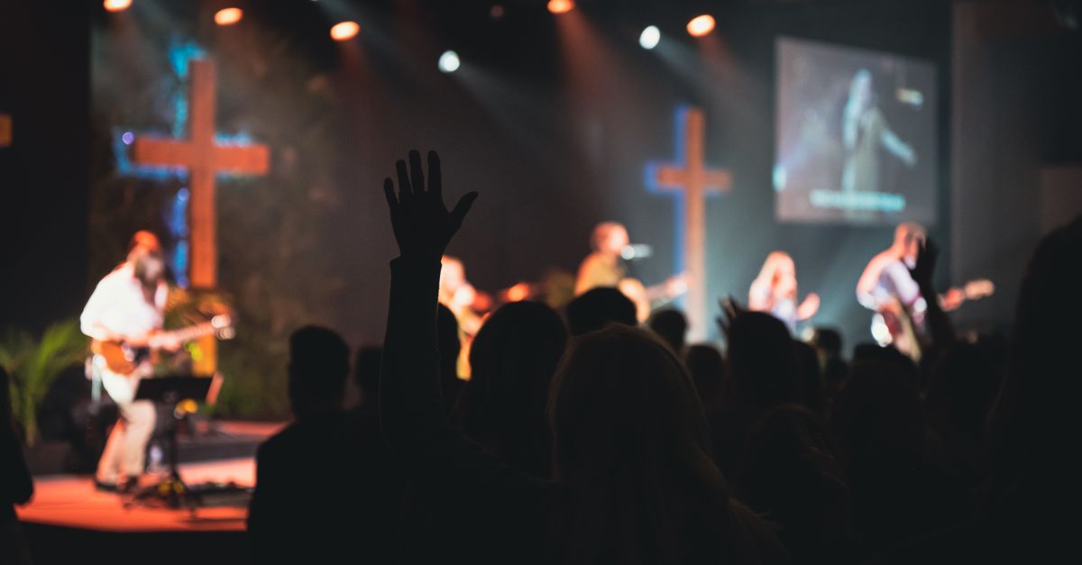 A vibrant church music band performing on stage with guitars and singers.